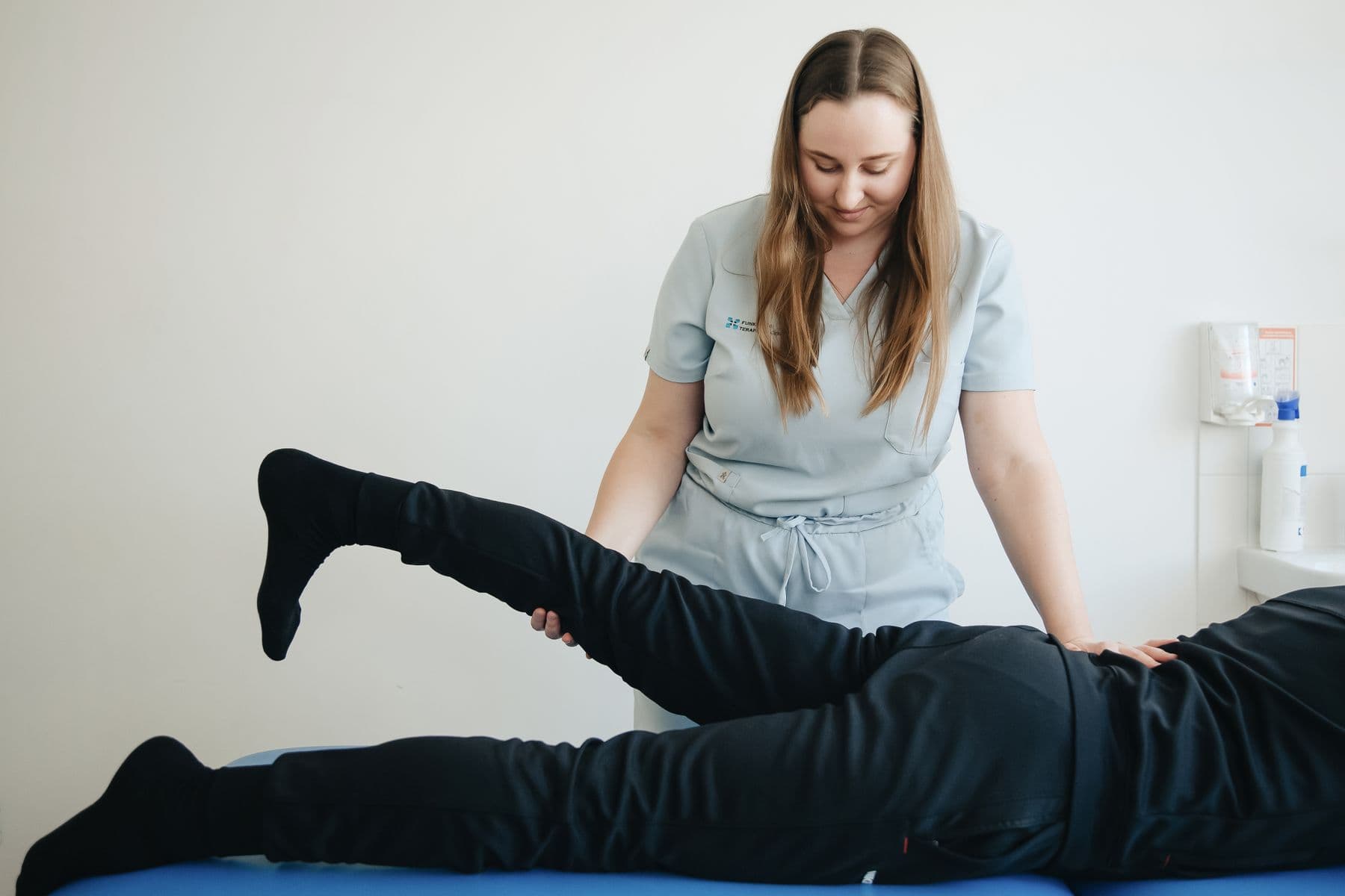 Premium physiotherapy room with treatment table, resistance bands, and rehabilitation tools